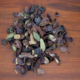 close up view of green, blue, brown, cacao loose tea pile on wooden table