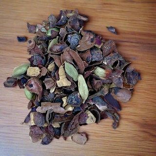 close up view of green, blue, brown, cacao loose tea pile on wooden table