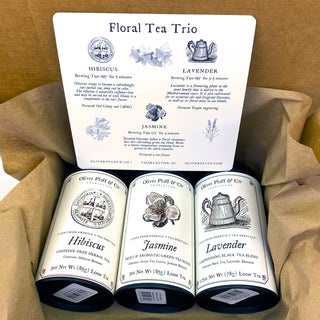 three black tea tins in brown packaging with instructions for floral tea brewing