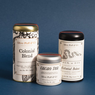 three tea tins, 5oz ground coffee, 3oz Colonial Bohea loose tea, 1.5oz roasted cacao loose tea. Blue background