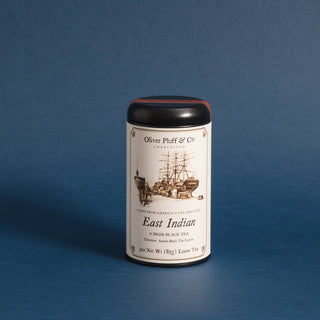 black tea tin with old timey ship on label against blue background