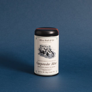 black tea tin with old timey graphic on label against blue backdrop