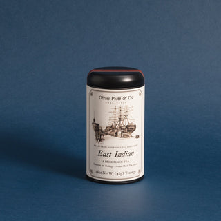 black tea tin with old timey ship against blue backdrop