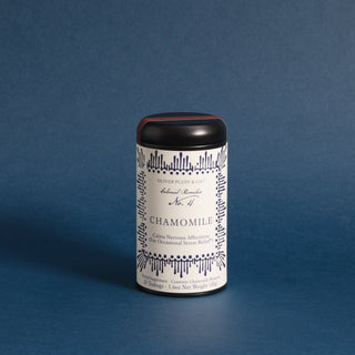 black tea tin with blue designs on label against blue backdrop