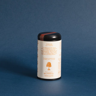 black tea tin with orange pattern against blue backdrop