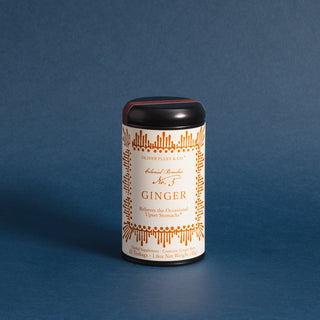 black tea tin with orange pattern against blue backdrop