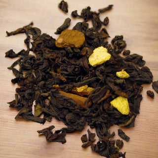 zoomed in photo of dark green and yellow loose leaf tea on wooden table