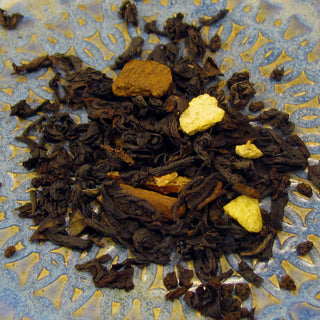 close up view of loose leaf tea, dark green and yellow flakes on blue and yellow plate