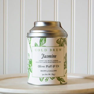 small silver tea tin with green flowery design sitting on white kitchen plate