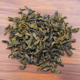 Green tea leaves on wooden table