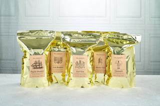 row of 5 shiny gold tea pouches sitting on white counter