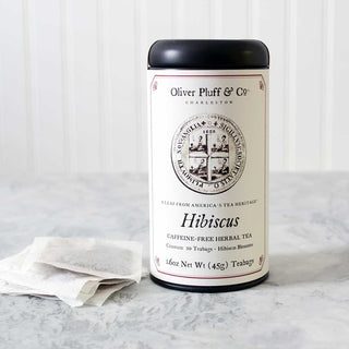 black tea tin sitting beside stack of white meshed tea bags on kitchen counter