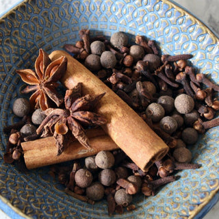 cinnamon sticks, cloves, allspice, star anise, in blue plate