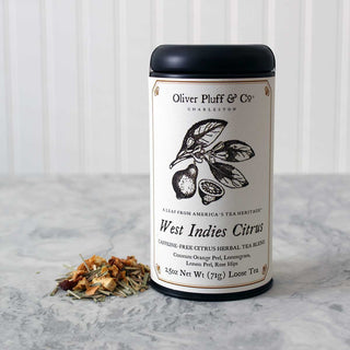 2.5oz loose leaf tea, sealed in matte black signature tea tin beside loose leaf tea ingredients on white counter